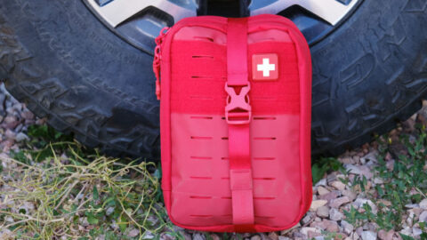 My Medic first aid kit shown in its red package against a van wheel.