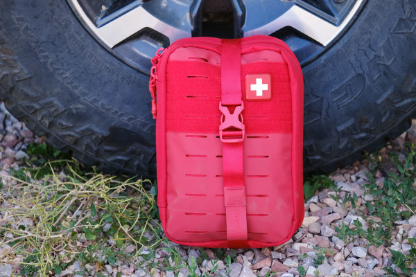 My Medic first aid kit shown in its red package against a van wheel.