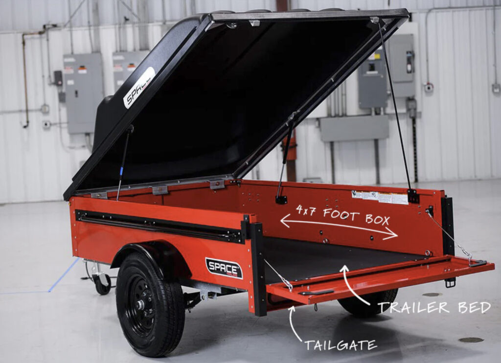 Diagram of an open red SPACE trailer with the top up and tailgate down