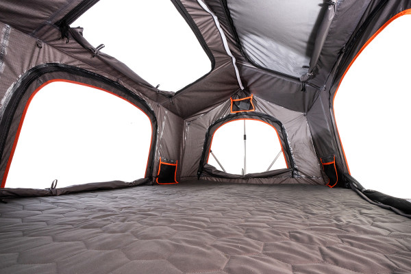 Meadowlark XL Roofnest car-top tent in gray with orange trim is shown, set up and empty, from the inside corner