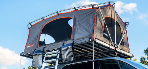 Meadowlark XL Roofnest car-top tent in gray with orange trim is shown, set up with the windows open.